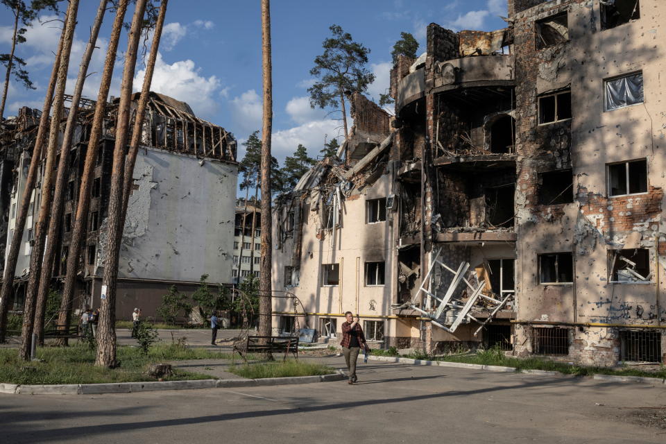 People look at destroyed buildings in Irpin, outside Kyiv, as Russia's attacks on Ukraine continues, June 9, 2022. REUTERS/Marko Djurica