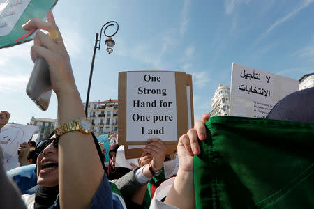 A demonstrator carries a sign as teachers and students take part in a protest demanding immediate political change in Algiers, Algeria March 13, 2019. REUTERS/Zohra Bensemra