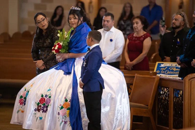 Jessica and Memo accompany Karina to lay flowers in front of an image of the Virgin of Guadalupe.