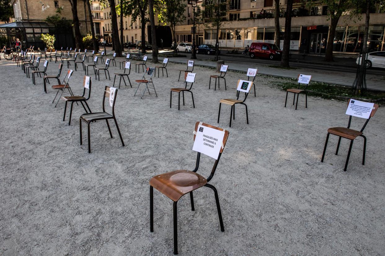 Chairs bearing the sign "fragile, but determined to go on" are splayed along the Bassin de la Vilette in Paris to protest against the closing of bars and cafes to fight against the spread of coronavirus epidemic on May 19, 2020.