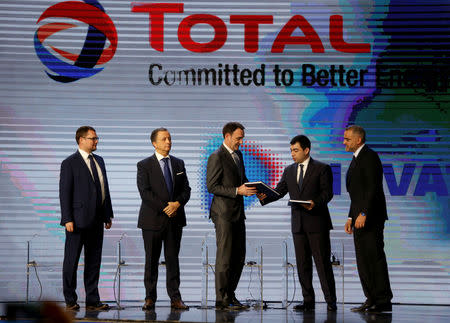 FILE PHOTO: Lebanese Energy Minister Cesar Abi Khalil hands a document to Stephane Michel, Total's head of exploration and production in the Middle East and North Africa, during Lebanon's first offshore oil and gas contract ceremony in Beirut, Lebanon February 9, 2018. REUTERS/Mohamed Azakir/File Photo