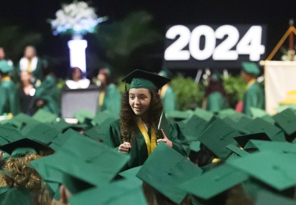 A fist bump for a classmate during DeLand High School graduation ceremonies at the Ocean Center in Daytona Beach on Tuesday.