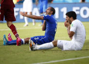 Uruguay's Luis Suarez (R) reacts after clashing with Italy's Giorgio Chiellini June 24, 2014. The Italians were still complaining about the incident when Uruguay captain Diego Godin scored with an 81st-minute header to secure a 1-0 win that sent them into the second round and eliminated Italy. REUTERS/Tony Gentile