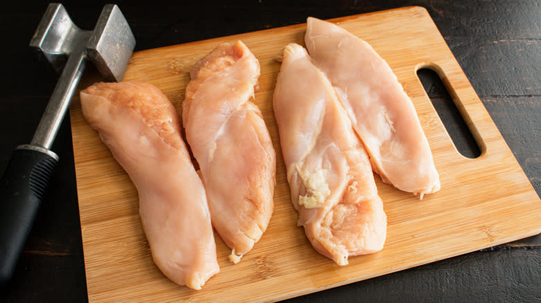 chicken breasts on wooden board