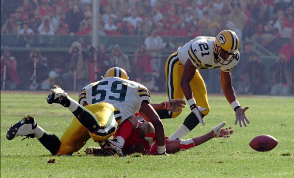 FILE - Green Bay Packers cornerback Craig Newsome (21) stretches to pick up a ball fumbled by San Francisco 49ers fullback Adam Walker, who was hit by Packers' Wayne Simmons (59) during the first quarter of an NFC playoff NFL football game Jan 6, 1996, in San Francisco. Newsome took the ball to the end zone for a 33-yard touchdown. Packers quarterback Brett Favre followed with two quick touchdown passes as Green Bay rolled to a 27-17 win. (AP Photo/Susan Ragan, File)