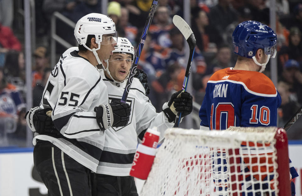 Los Angles Kings' Quinton Byfield (55) and Trevor Moore (12) celebrate after a goal against the Edmonton Oilers during first-period NHL hockey game action in Edmonton, Alberta, Monday, Feb. 26, 2024. (Jason Franson/The Canadian Press via AP)