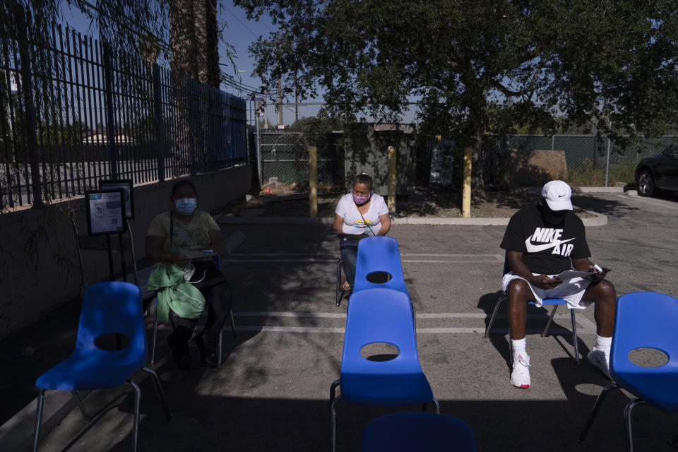 People hold in the observation area after receiving the Johnson & Johnson's COVID-19 vaccine at a Cedars-Sinai sponsored pop-up vaccine clinic at the Watts-Willowbrook Boys & Girls Club in Los Angeles, Wednesday, April 28, 2021. California, swimming in vaccine, is in a far different place than it was just weeks ago when simply scoring an appointment was cause for celebration. Today, Los Angeles, San Diego and other populous counties are advertising that anyone can walk in for a shot and the state is texting reminders that plenty of appointments are available. (AP Photo/Jae C. Hong)