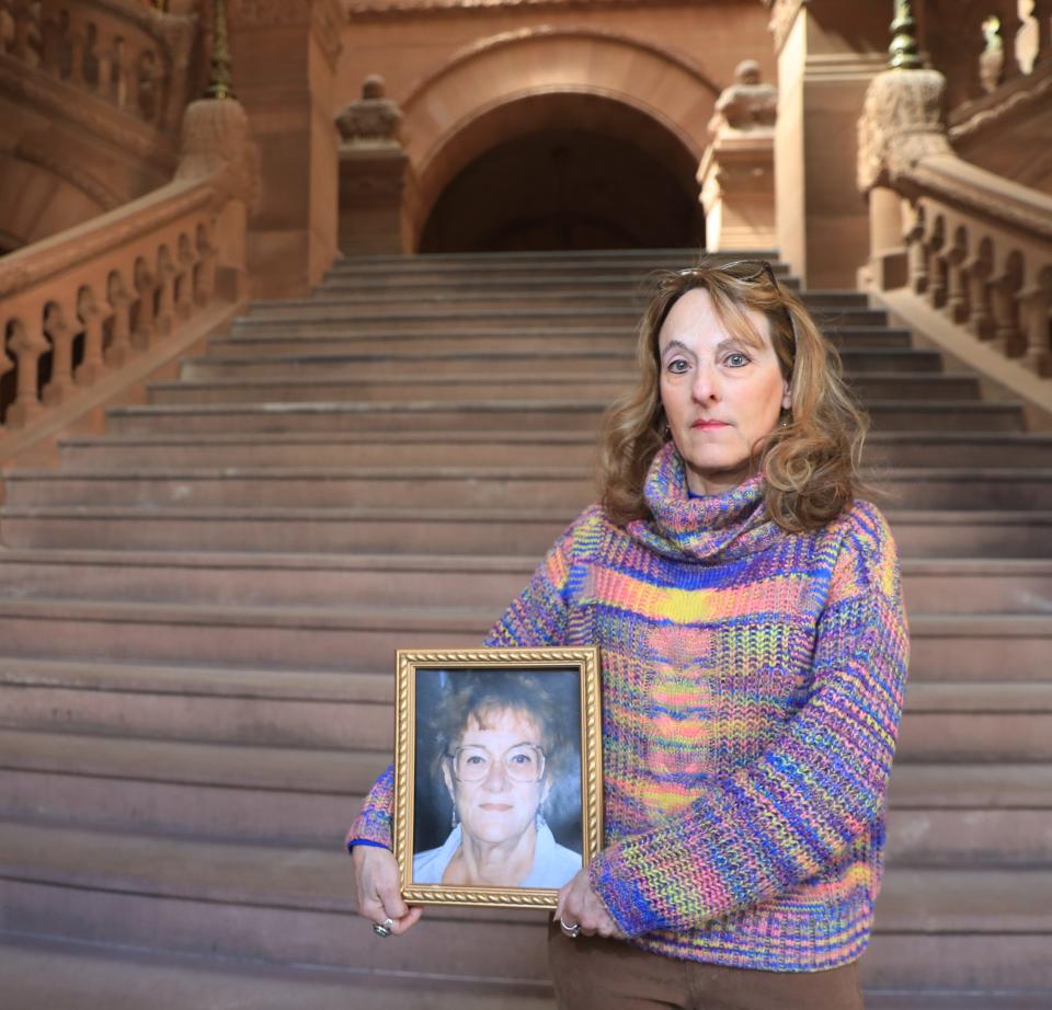 Mary Beth Delarm holds a photo of her mother, Pat Ashley while at the New York State Capitol on April 20, 2022. Ashley died in May 2020 while in a nursing home in Rensselaer County.  