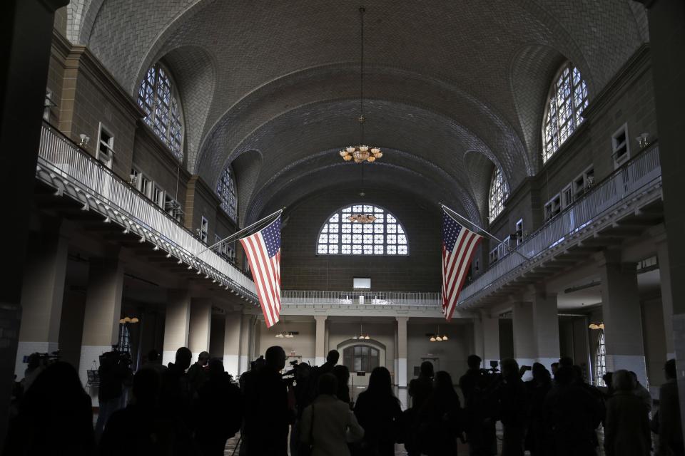 Reporters gather in the registry room at Ellis Island in New York, Monday, Oct. 28, 2013. The island that ushered millions of immigrants into the United States received visitors Monday for the first time since Superstorm Sandy. Sandy swamped boilers and electrical systems and left the 27.5-acre island without power for months. (AP Photo/Seth Wenig)