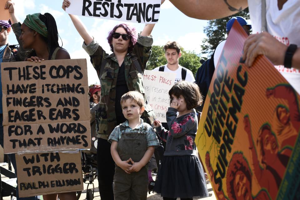 A woman and her children join hundreds of protesters gathering at Lincoln Park to take part in a march for racial justice in Washington, D.C., on Sept. 30, 2017.