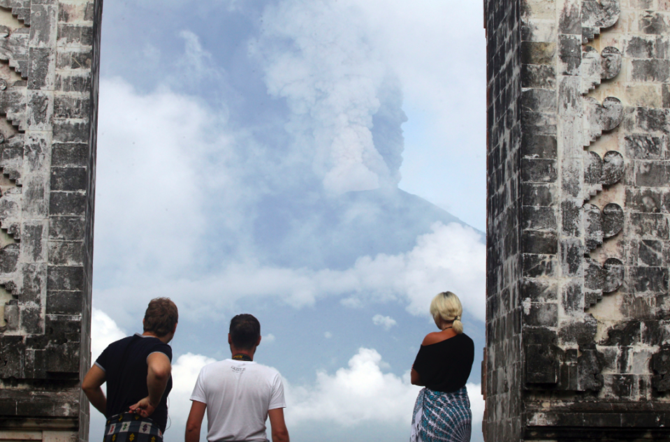 <em>Tourists stop to stare at the as cloud from the volcano (AP)</em>