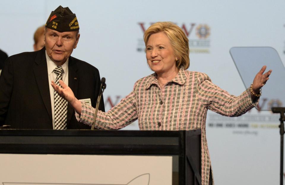 Hillary Clinton, the presumptive Democratic presidential nominee, gestures to the crowd as VFW Commander-in-Chief John A. Biedrzycki Jr. looks on after she addressed the 117th annual VFW National Convention at the Charlotte Convention center on July 25, 2016, in Charlotte, N.C. (David T. Foster III/Charlotte Observer/TNS via Getty Images)