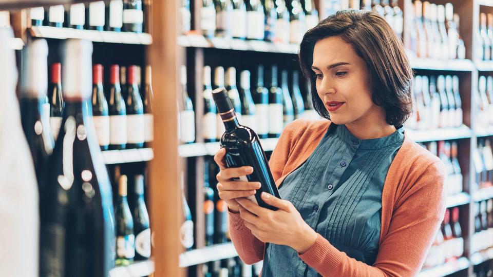 Young woman shopping for wine.