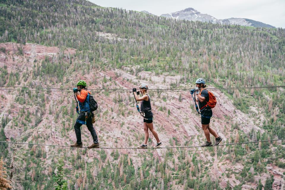 Walking across a wire suspension bride on the Gold Mt. Expedition Ferrata