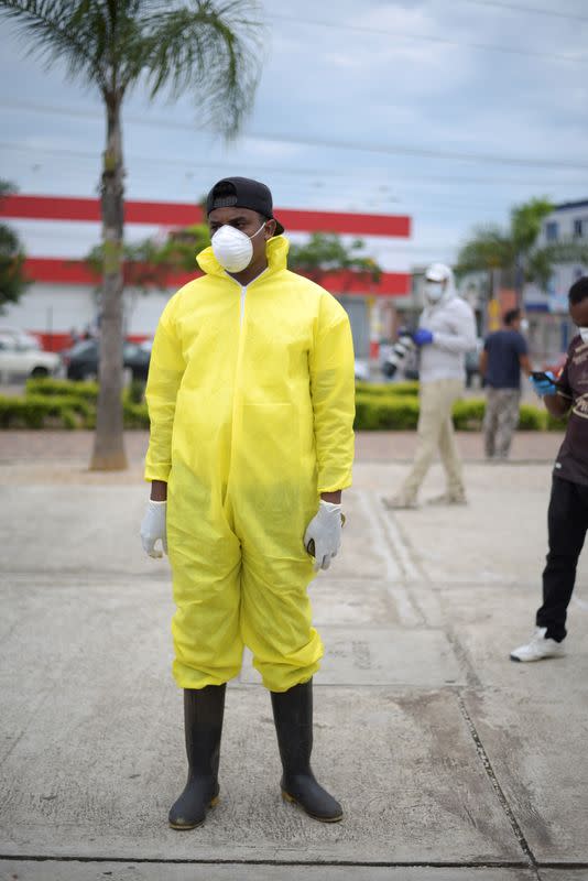 A funeral home worker wears a protective suit while waiting outside Guasmo Sur General Hospital after Ecuador reported new cases of coronavirus disease (COVID-19), in Guayaquil