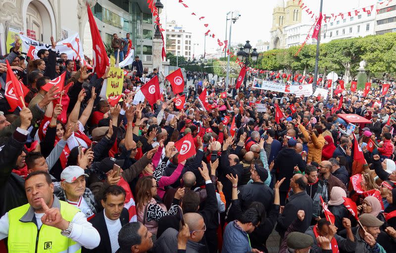 Supporters of Tunisia's President Kais Saied carry flags and banners during a rally in Tunis