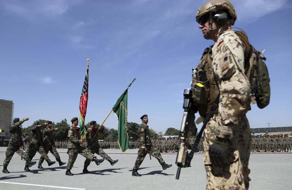 A NATO forces stands guard during the graduation ceremony of newly Afghan National Army soldiers after a 3-month training program at the Afghan Military Academy in Kabul, Afghanistan, Wednesday, July 10, 2019. (AP Photo/Rahmat Gul)