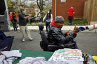 In this March 31, 2020, photo, James Hart, 64, gets a fist bump from entrepreneur Jimmie Jenkins, as Hart receives a bag of donated groceries in his wheelchair in southeast Washington. The neighborhood deliveries are part of a new Martha's Table initiative, along with community partners, to get needed food directly to the neighborhoods they serve. These local volunteers are the tip of the spear for a grassroots community effort to keep Washington's most vulnerable neighborhoods fed during the unprecedented coronavirus crisis which has nearly shut down the American economy. (AP Photo/Jacquelyn Martin)