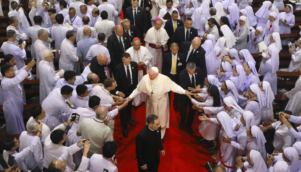 Priests, religious seminarians and Catechists touch the hands of Pope Francis as he leaves after meeting them at Saint Peter's Parish on the outskirts of Bangkok, Thailand, Friday, Nov. 22, 2019. Pope Francis urged more efforts to combat the "humiliation" of women and children forced into prostitution as he began a busy visit Thursday to Thailand, where human trafficking and poverty help fuel the sex tourism industry. (AP Photo/Manish Swarup)