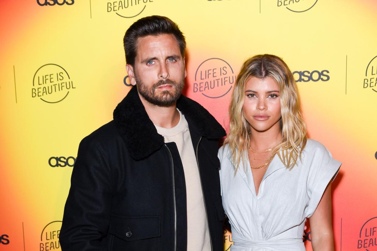 A rare photo of Scott Disick in casual jacket and denim pant, beside his girlfriend, Sofia Richie, who is dressed in a lovely white jumpsuit.