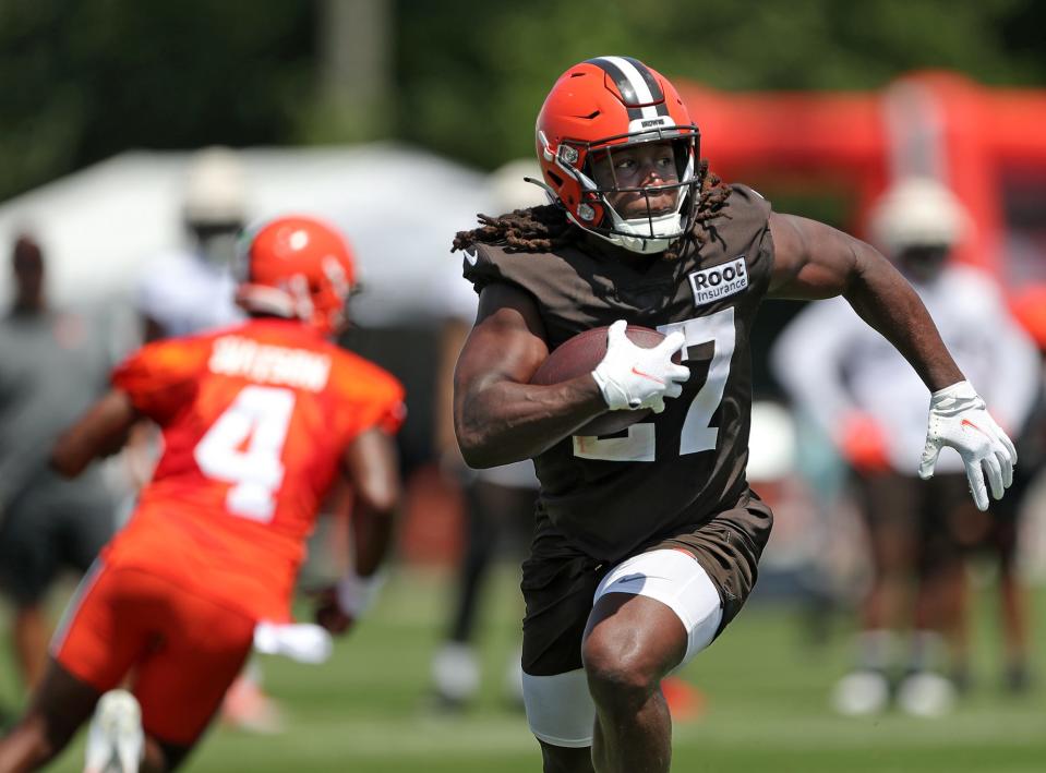 Cleveland Browns running back Kareem Hunt rushes for yards after taking a handoff from quarterback Deshaun Watson during the NFL football team's football training camp in Berea on Wednesday.