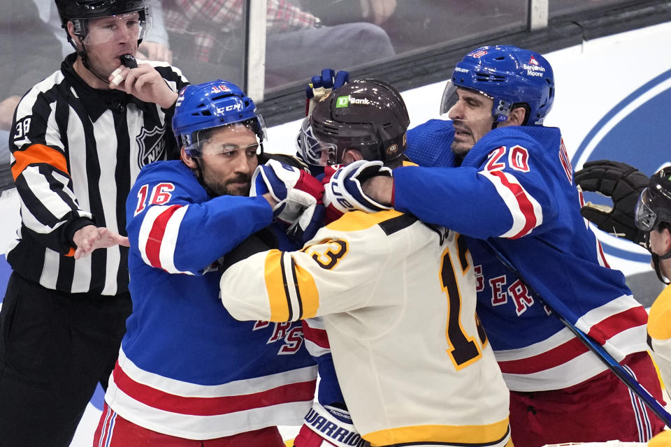 Boston Bruins center Charlie Coyle (13) is surrounded by New York Rangers center Vincent Trocheck (16) and left wing Chris Kreider (20) during the first period of an NHL hockey game, Saturday, Dec. 16, 2023, in Boston. (AP Photo/Charles Krupa)