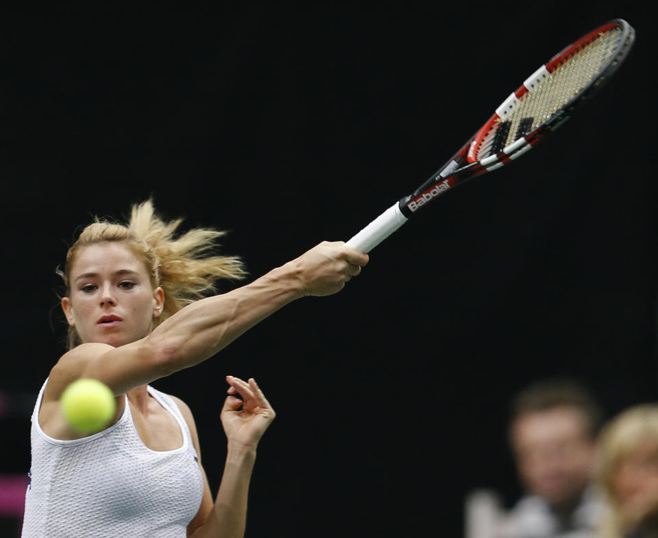 Italy's Camila Giorgi returns a ball to Czech Republic's Petra Kvitova during their Fed Cup semifinal tennis match in Ostrava, Czech Republic, Saturday, April 19, 2014. (AP Photo/Petr David Josek)