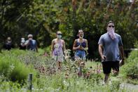 People walk along the High Line Park, Thursday, July 16, 2020, in New York. The Highline opened today after having been closed the last few months during the pandemic. (AP Photo/Frank Franklin II)
