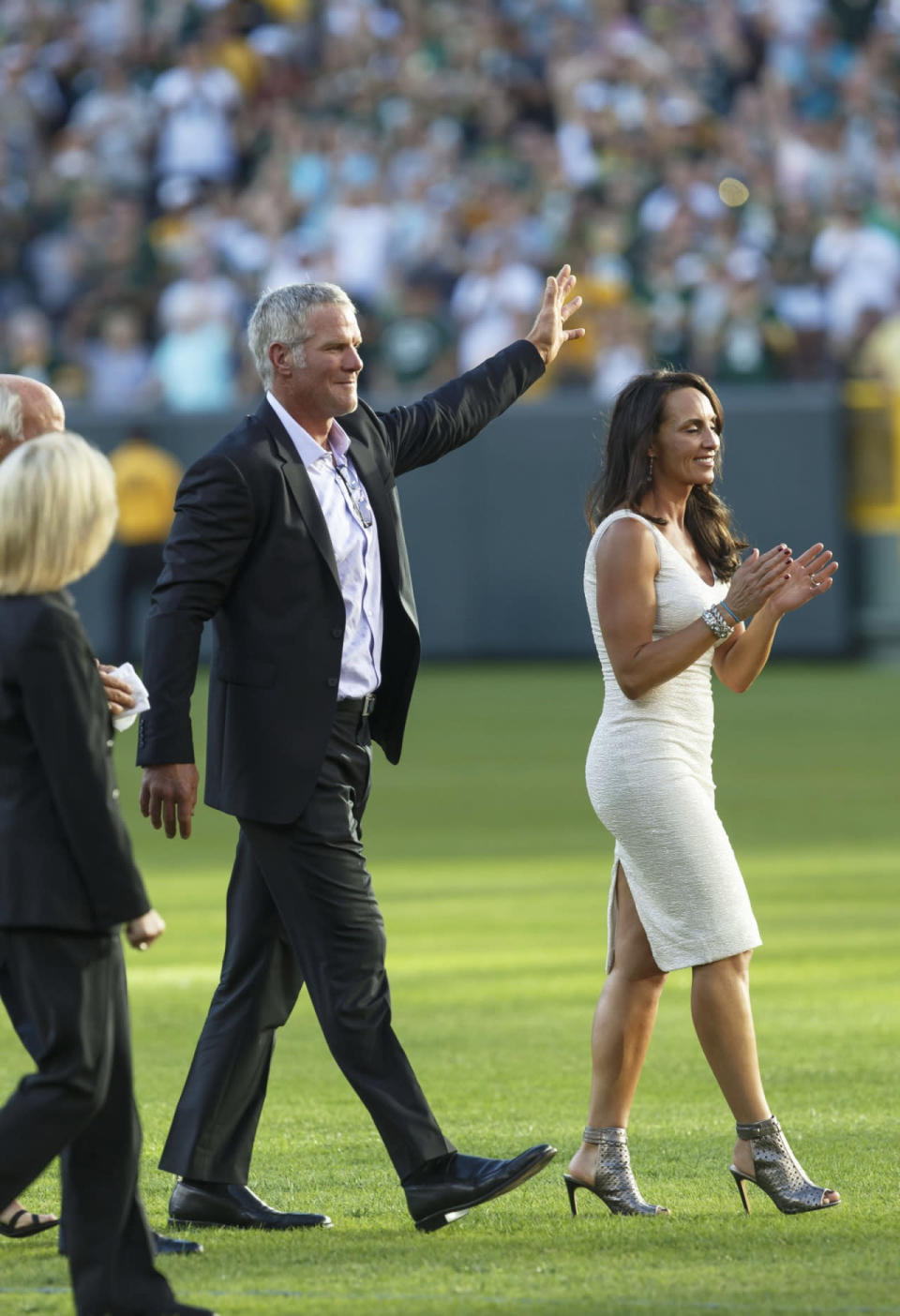 <p>With his wife, Deanna, at his side former Green Bay Packers quarterback Brett Favre waves to fans as he walks off Lambeau Field prior to his induction into he Packers Hall of Fame and having his No. 4 jersey retired, Saturday, July 18, 2015, in Green Bay, Wis. (AP Photo/Mike Roemer)</p>