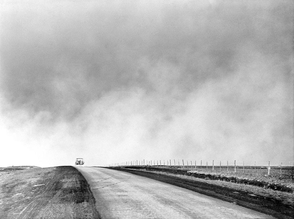 A dust storm chases a car over the Texas Panhandle during the Dust Bowl years.