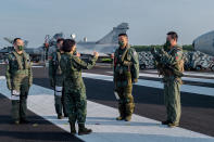 In this photo released by the Taiwan Presidential Office, Taiwanese President Tsai Ing-wen, center, speaks with military personnel near aircraft parked on a highway in Jiadong, Taiwan, Wednesday, Sept. 15, 2021. Four military aircraft landed on the highway and took off again on Wednesday as part of Taiwan's five-day Han Guang military exercise designed to prepare the island's forces for an attack by China, which claims Taiwan as part of its own territory. (Taiwan Presidential Office via AP)