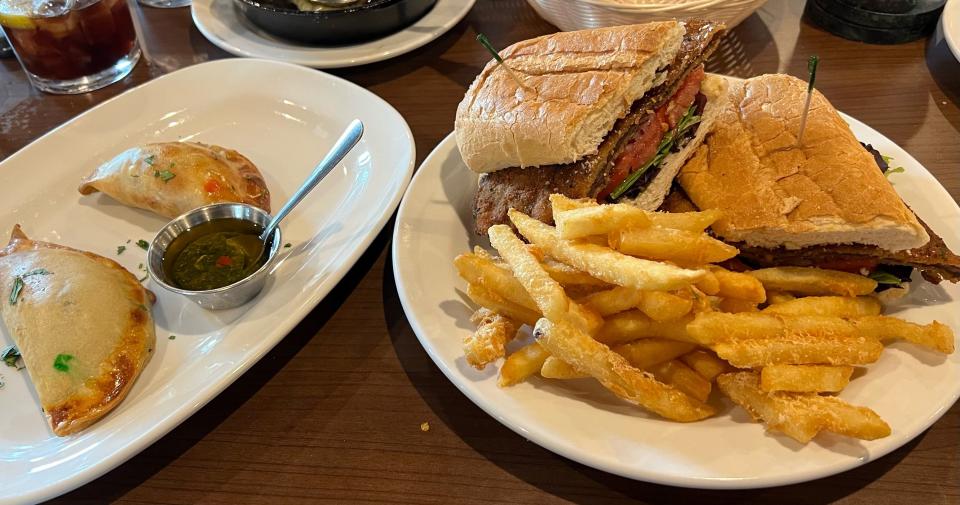 The milanesa sandwich and empanadas, both offered at El Gaucho, are staples of Argentinian cuisine.