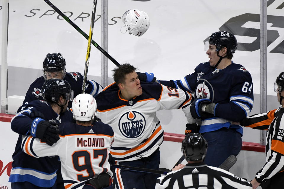 Winnipeg Jets' Logan Stanley (64) and Edmonton Oilers' Jesse Puljujarvi (13) push and shove following a whistle during the first period of an NHL game against the Winnipeg Jets, in Winnipeg, Manitoba on Sunday, May 23, 2021. (Fred Greenslade/The Canadian Press via AP)