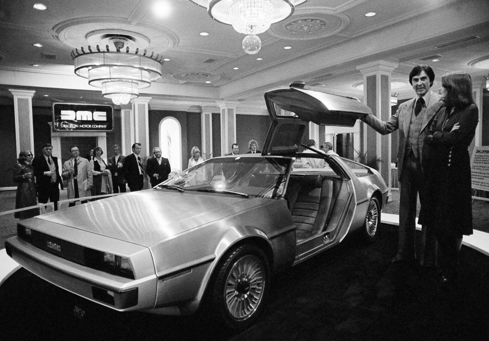 John Z. Delorean and his wife Christina, of Detroit, stand by his prototype car, Model 12, that was unveiled in New Orleans, La., Jan. 31, 1977. The brushed steel and fiber glass sports car is scheduled for production in 1979 with a six-cylinder engine, reported to get 30 miles per gallon on the highway. The cost: around $10,000. (AP Photo/Jack Thornell)