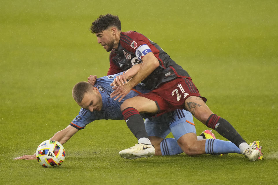 Toronto FC midfielder Jonathan Osorio (21) forces New York City FC midfielder James Sands (6) to the turf during the first half of an MLS soccer match Saturday, May 11, 2024, in Toronto. (Frank Gunn/The Canadian Press via AP)