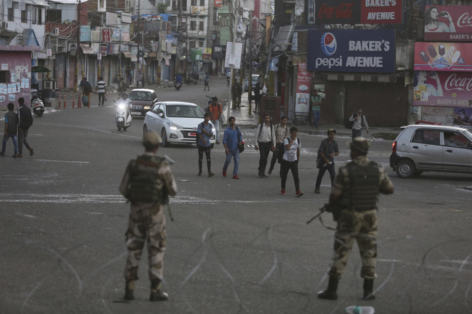 Indian paramilitary soldiers stand guard during curfew like restrictions in Jammu, India, Monday, Aug. 5, 2019. An indefinite security lockdown was in place in the Indian-controlled portion of divided Kashmir on Monday, stranding millions in their homes as authorities also suspended some internet services and deployed thousands of fresh troops around the increasingly tense region. (AP Photo/Channi Anand)