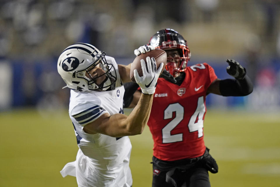 BYU wide receiver Gunner Romney, left, catches a pass next to Western Kentucky defensive back Roger Cray (24) during the first half of an NCAA college football game Saturday, Oct. 31, 2020, in Provo, Utah. (AP Photo/Rick Bowmer, Pool)