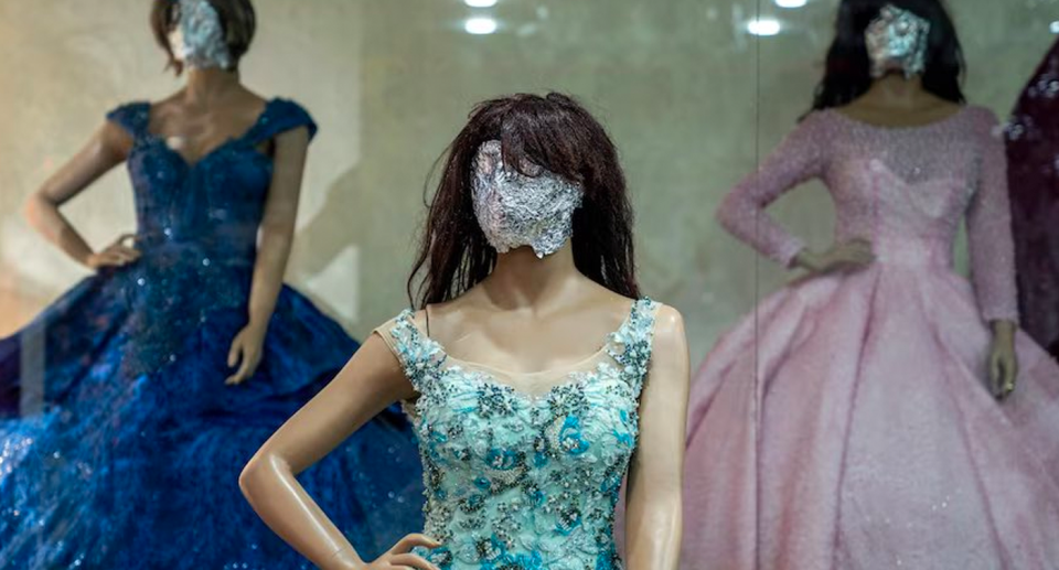 Mannequin faces covered in tin foil in a shop.