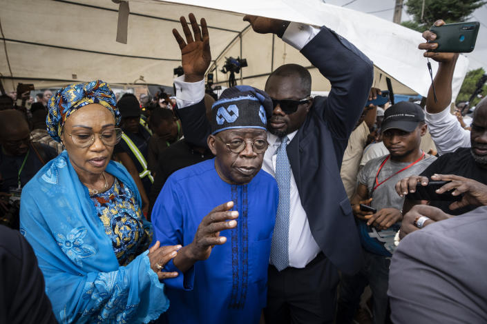 FILE - Presidential candidate Bola Tinubu, center, of the All Progressives Congress, accompanied by his wife Oluremi Tinubu, left, gestures to supporters after casting his vote in the presidential elections in Lagos, Nigeria, Feb. 25, 2023. Election officials declared ruling party candidate Bola Tinubu the winner of Nigeria's presidential election early Wednesday, March 1, 2023, with the two leading opposition candidates already demanding a revote in Africa's most populous nation. (AP Photo/Ben Curtis, File)