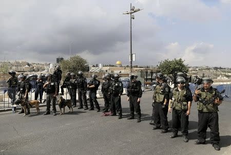 The Dome of the Rock is seen in the background as Israeli policemen stand guard near Palestinian men (not pictured) participating in Friday prayers in Arab east Jerusalem neighbourhood of Ras al-Amud October 9, 2015. REUTERS/Ammar Awad