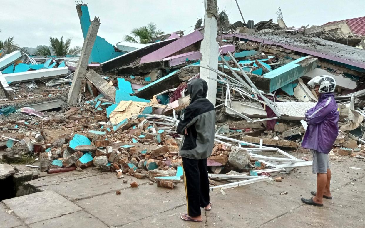 People look at a damaged hospital building following an earthquake in Mamuju, West Sulawesi province - Reuters