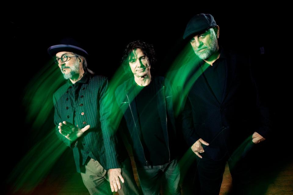 Three men in black with green lighting