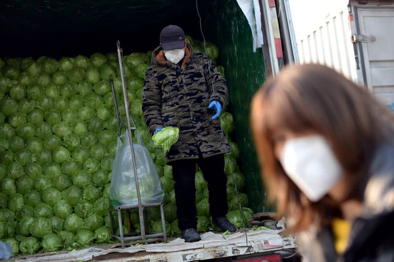 Man sorts vegetables on a truck at the Xinfadi wholesale market, as the country is hit by an outbreak of the novel coronavirus disease (COVID-19), in Beijing