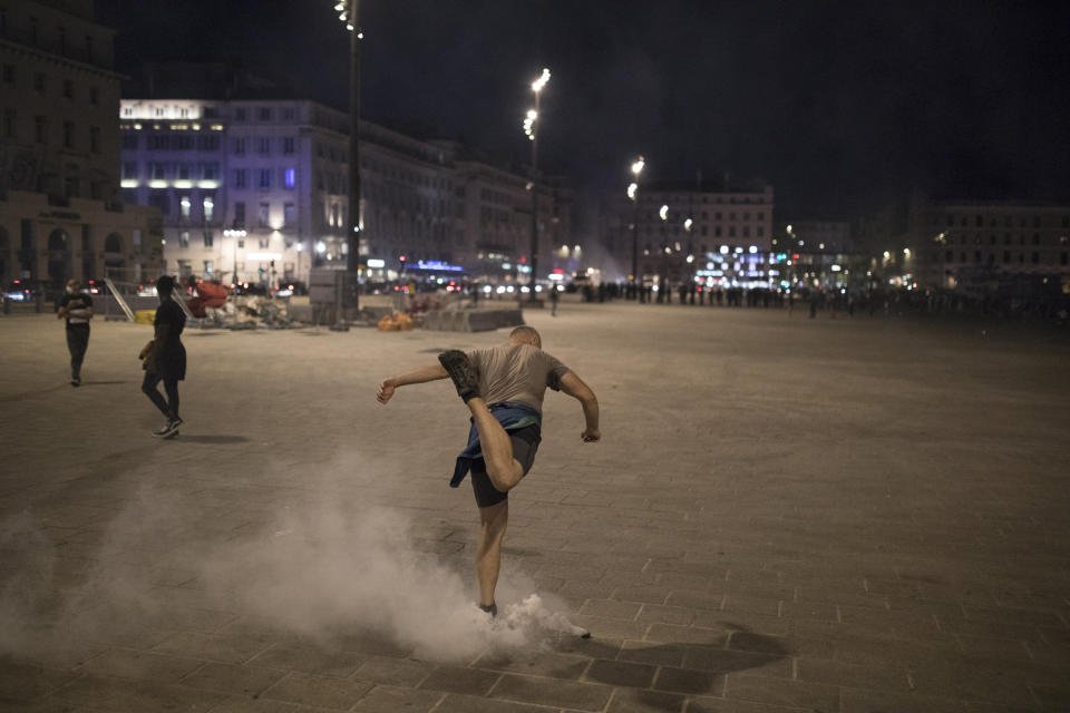 A protester kicks a tear gas canister fired by French riot police during a protest in Marseille, southern France, Saturday, June 6, 2020. Protesters marched against the death of George Floyd, a black man who died after he was restrained by police officers May 25 in Minneapolis, that has led to protests in many countries and across the U.S. Further protests are planned over the weekend in European cities, some defying restrictions imposed by authorities due to the coronavirus pandemic. (AP Photo/Daniel Cole)