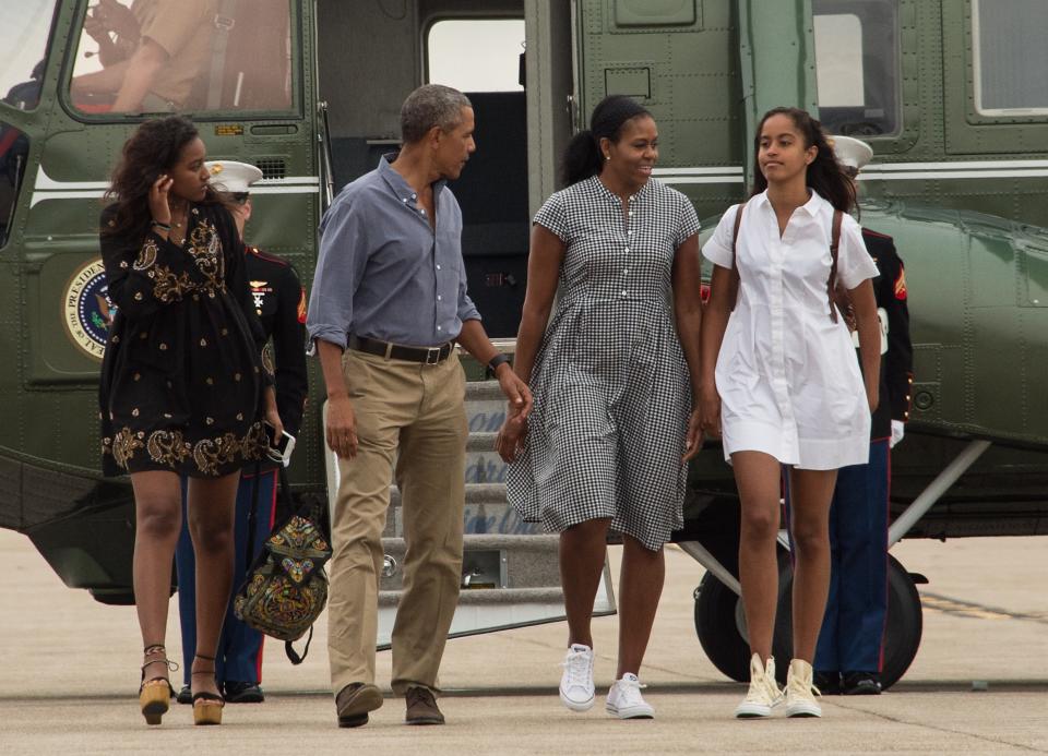US President Barack Obama, First Lady Michelle Obama and daughters Malia and Sasha walk to board Air Force One at Cape Cod Air Force Station in Massachusetts on August 21, 2016 as they depart for Washington after a two-week holiday at nearby Martha's Vineyard. / AFP / NICHOLAS KAMM        (Photo credit should read NICHOLAS KAMM/AFP/Getty Images)