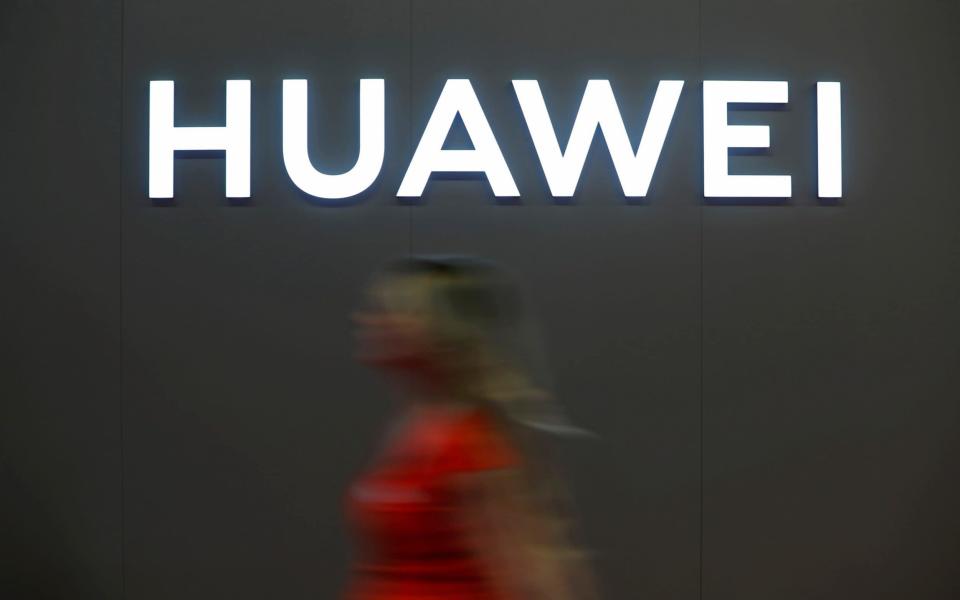 A woman walks in front of the Huawei logo during during the 'Electronics Show at Ptak Warsaw Expo in Nadarzyn, Poland. May 10, 2019.  - REUTERS
