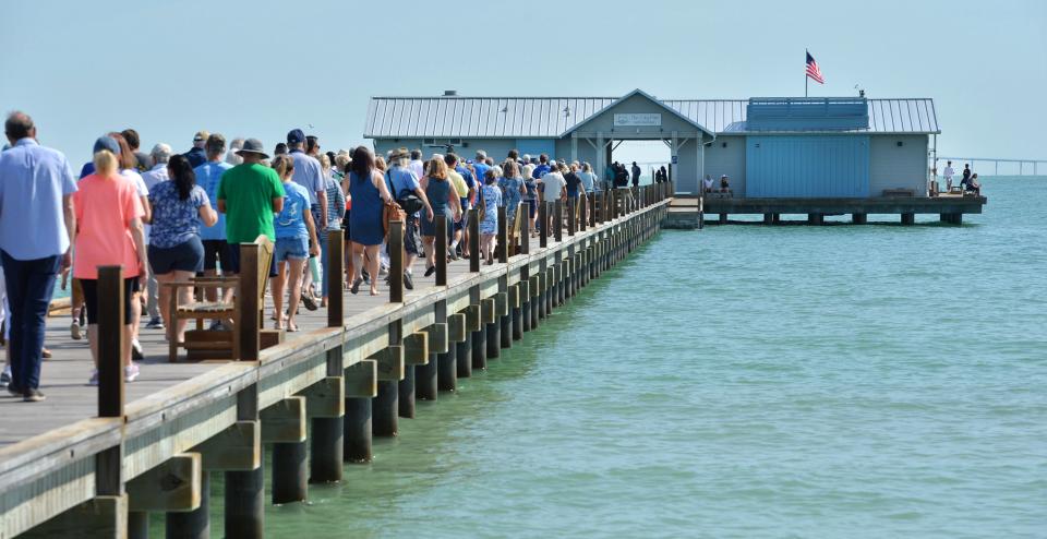 A large crowd walks on the Anna Maria City Pier hoping to be among the first people to see the new Mote Marine Laboratory's Marine Science Education & Outreach Center following a ribbon-cutting ceremony Friday morning. 