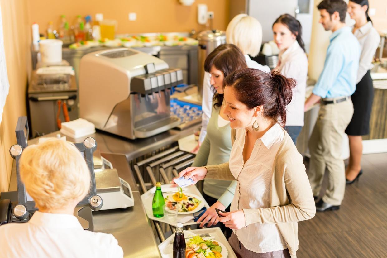 cafeteria woman pay at cashier hold serving tray fresh food