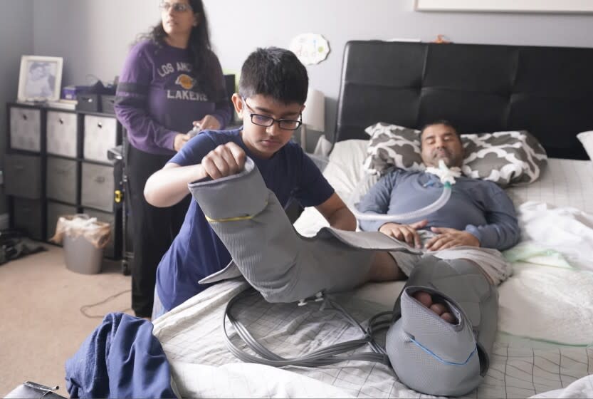 Ronan Kotiya, 11, removes a compression leg sleeve from his father Rupesh Kotiya as his mother Siobhan Pandya looks at their home in Plano, Texas, Sunday, April 10, 2022. Ronan helps care for his father who suffers from ALS and is dependent on a ventilator and around the clock care. Millions of Americans with serious health problems depend on children ages 18 and younger to provide some or all of their care at home. An exact number is hard to pin down, but researchers think millions of children are involved in caregiving in the U.S. Ronan helps care for his father who suffers from ALS and is dependent on a ventilator and around the clock care. Millions of Americans with serious health problems depend on children ages 18 and younger to provide some or all of their care at home. An exact number is hard to pin down, but researchers think millions of children are involved in caregiving in the U.S. (AP Photo/LM Otero)