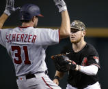 Washington Nationals' Max Scherzer gives himself up to Arizona Diamondbacks' Josh VanMeter after a bunt during the fifth inning of a baseball game Friday, May 14, 2021, in Phoenix. (AP Photo/Darryl Webb)